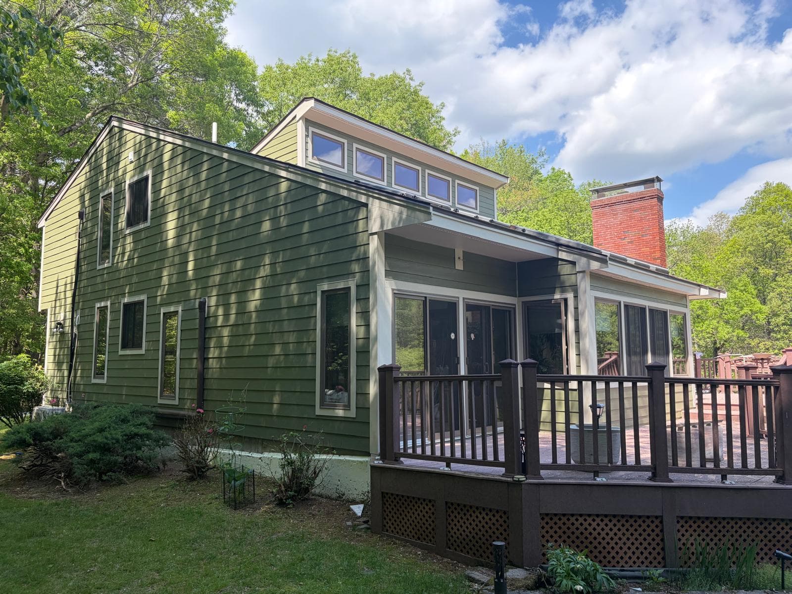 Side view of Carlisle home covered porch addition finished in James Hardie green with screen enclosure