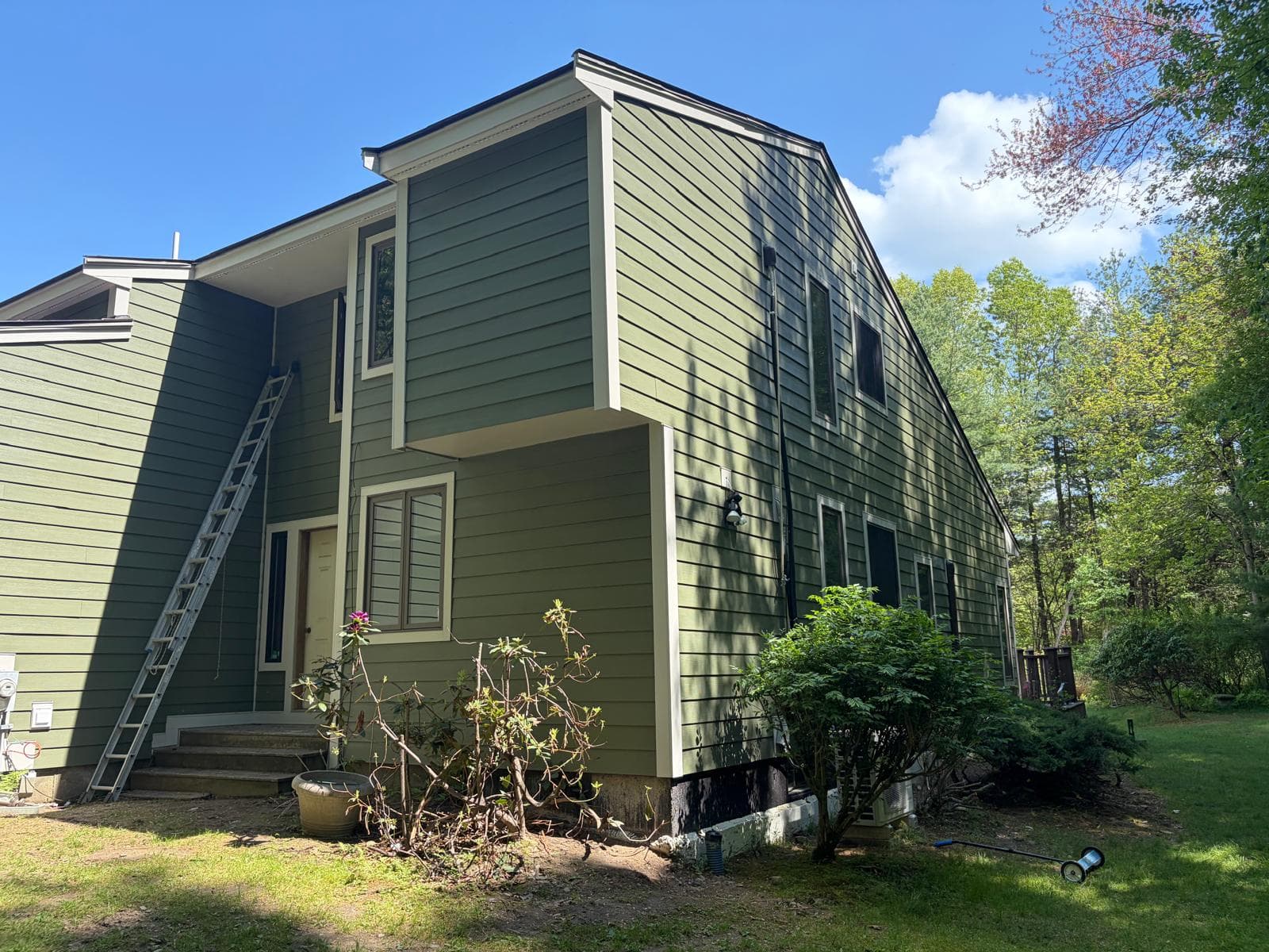 Side angle of completed Carlisle Hardie install showing window trim and corner board detail in green ColorPlus finish