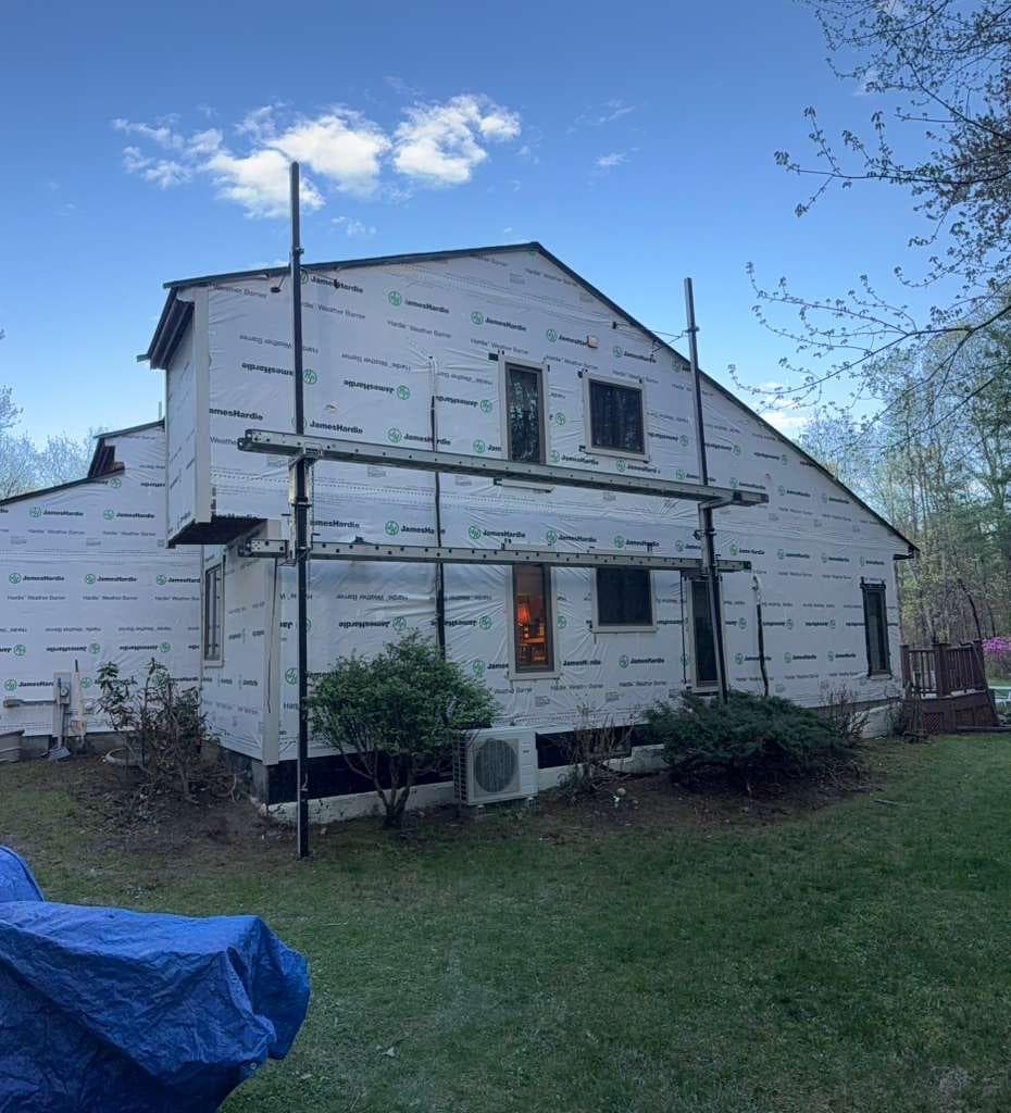 Back of Carlisle home wrapped in JamesHardie Weather Barrier with garage doors visible before Hardie Plank install