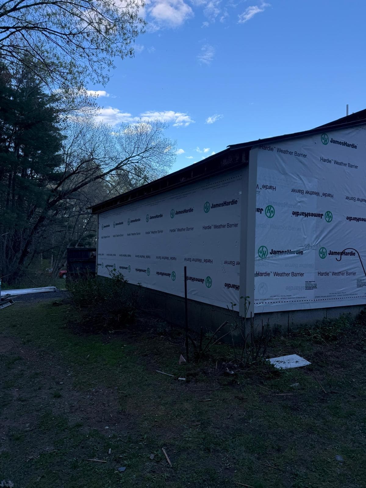Carlisle MA home at dusk fully wrapped in JamesHardie Weather Barrier ready for next-day plank install