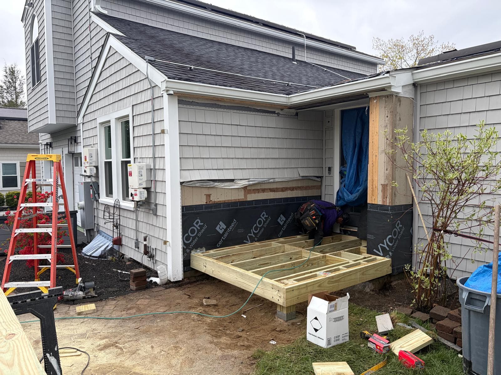 New porch floor framing on pressure-treated joists with Vycor Ice & Water Shield self-adhered to existing siding in Webster MA