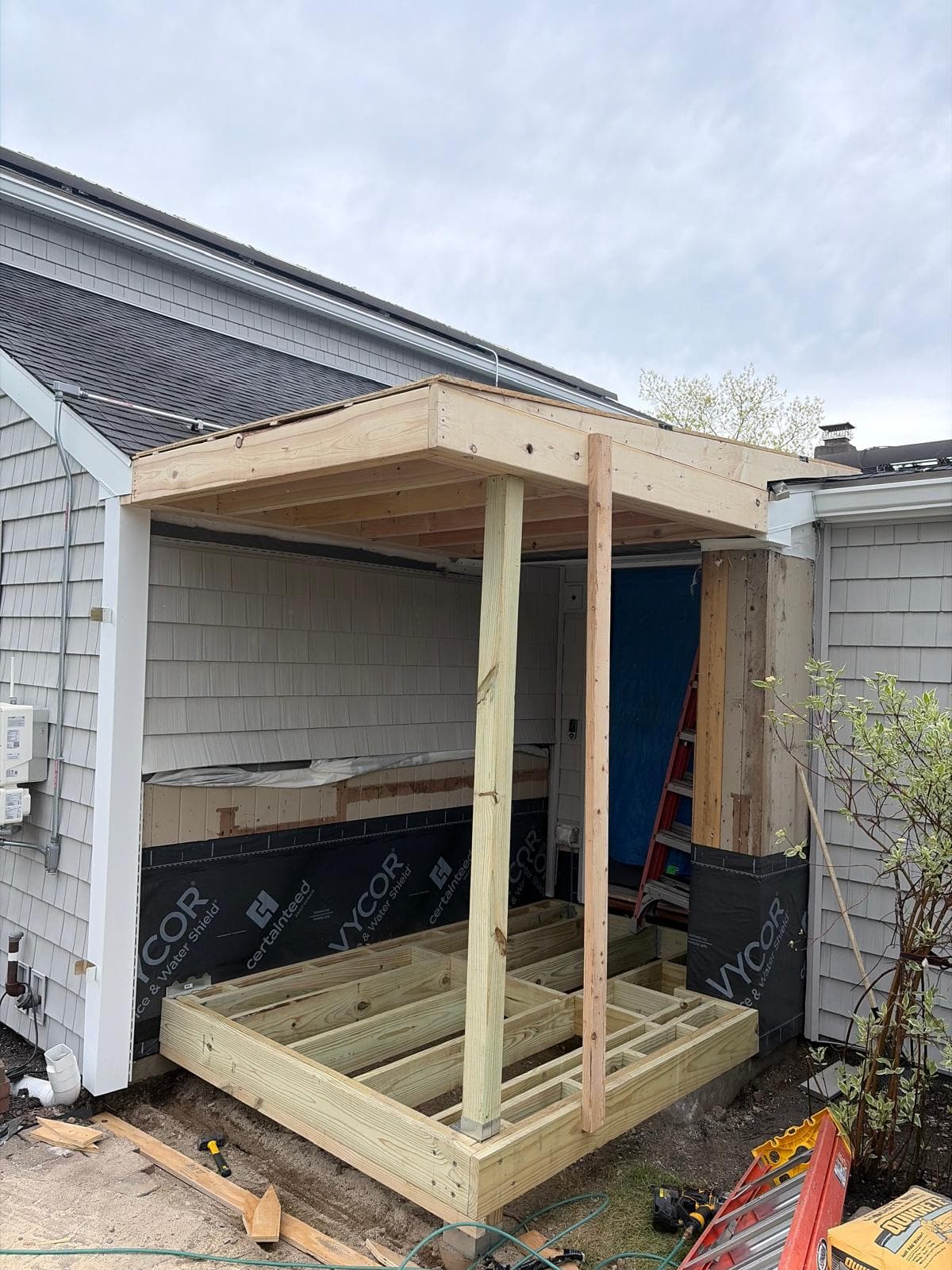 Close-up of porch frame structure with vertical posts and Vycor flashing visible during Webster MA porch addition