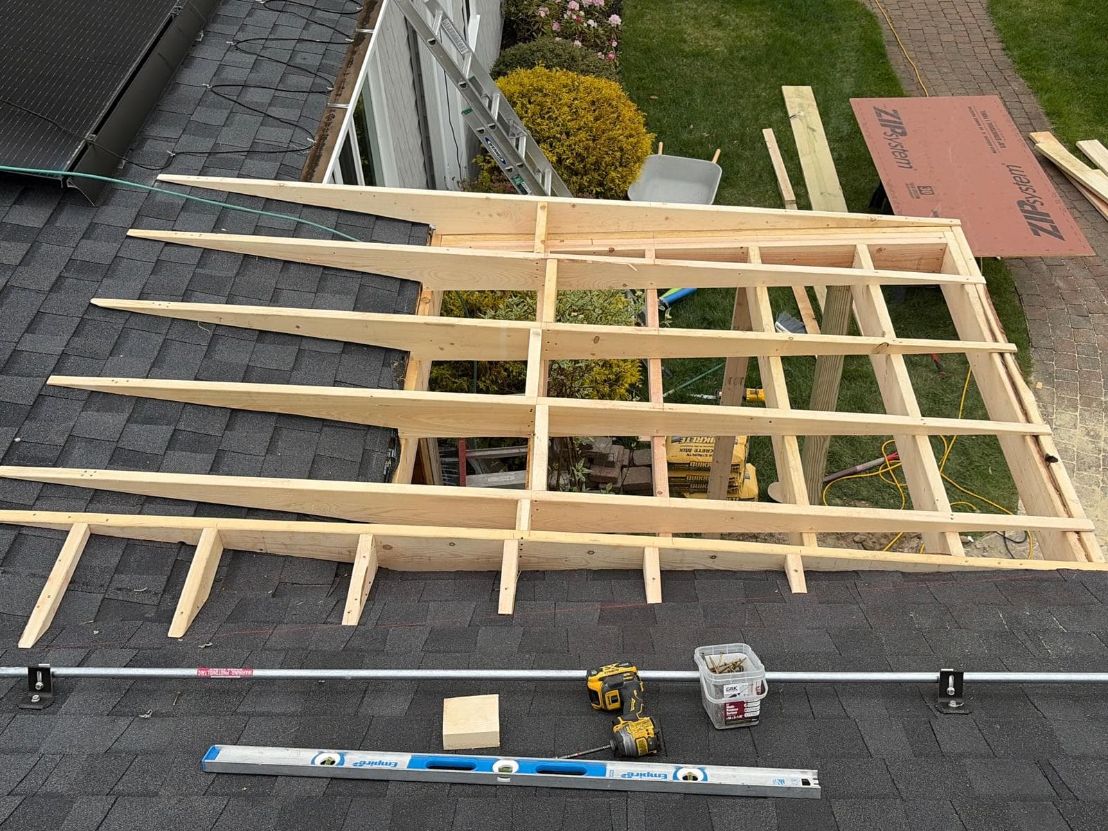 Aerial view of roof framing for porch addition in Webster MA — rafters tied to existing roof, level across the run