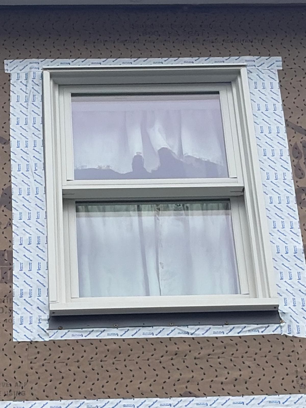 Close-up of double-hung window with full perimeter flashing tape over HydroGap weather barrier on Warren RI dormer re-side
